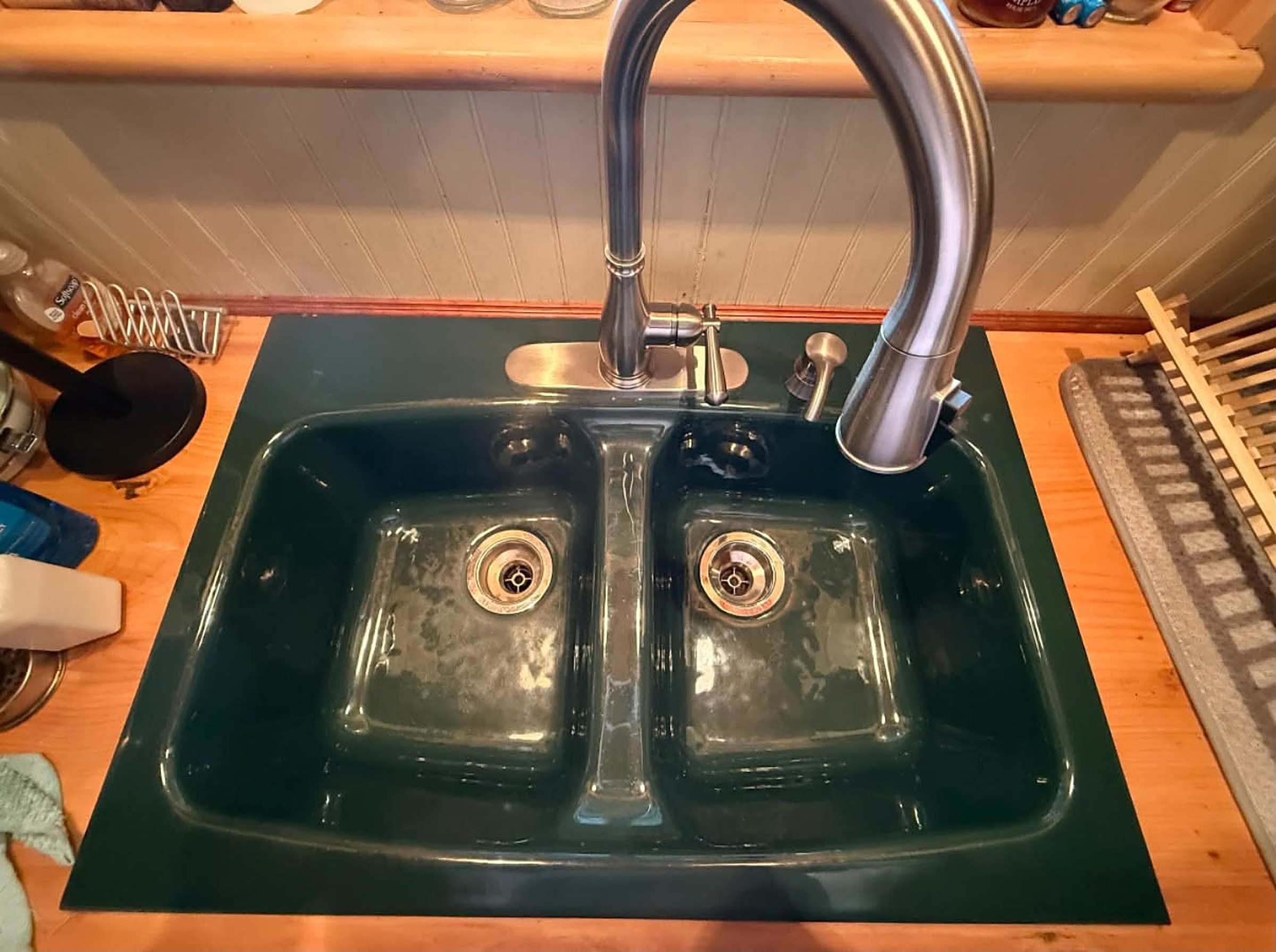 After: the same green double sink wiped clean, deep and glossy with no water spots